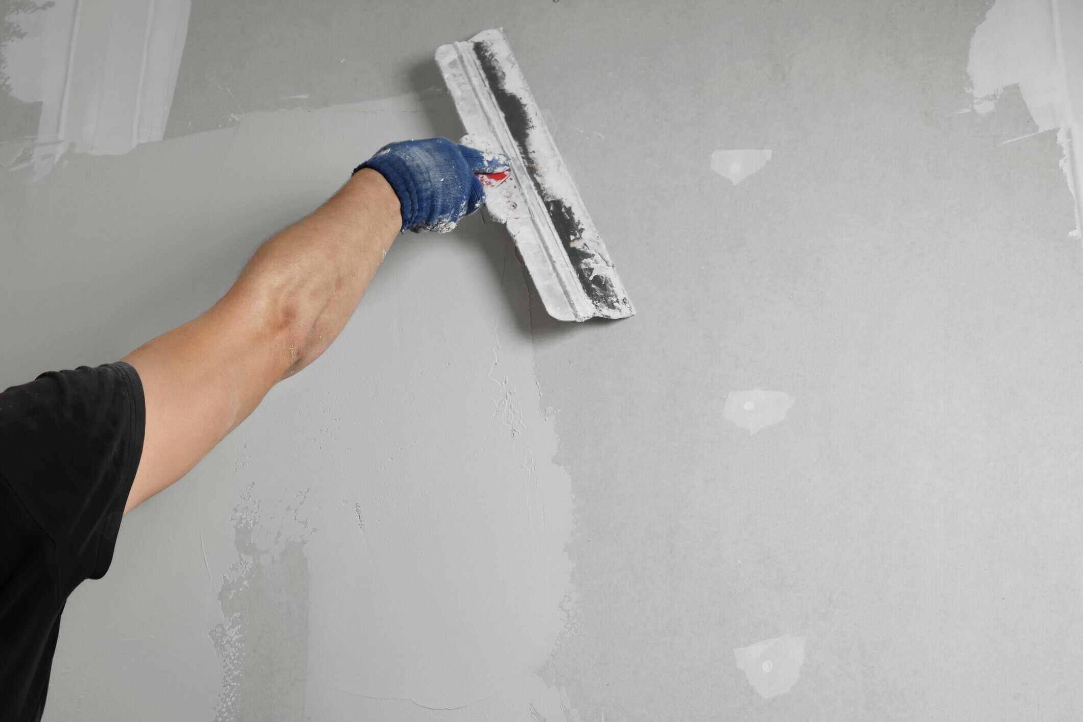 Professional worker plastering wall with putty knife, closeup how to paint textured walls